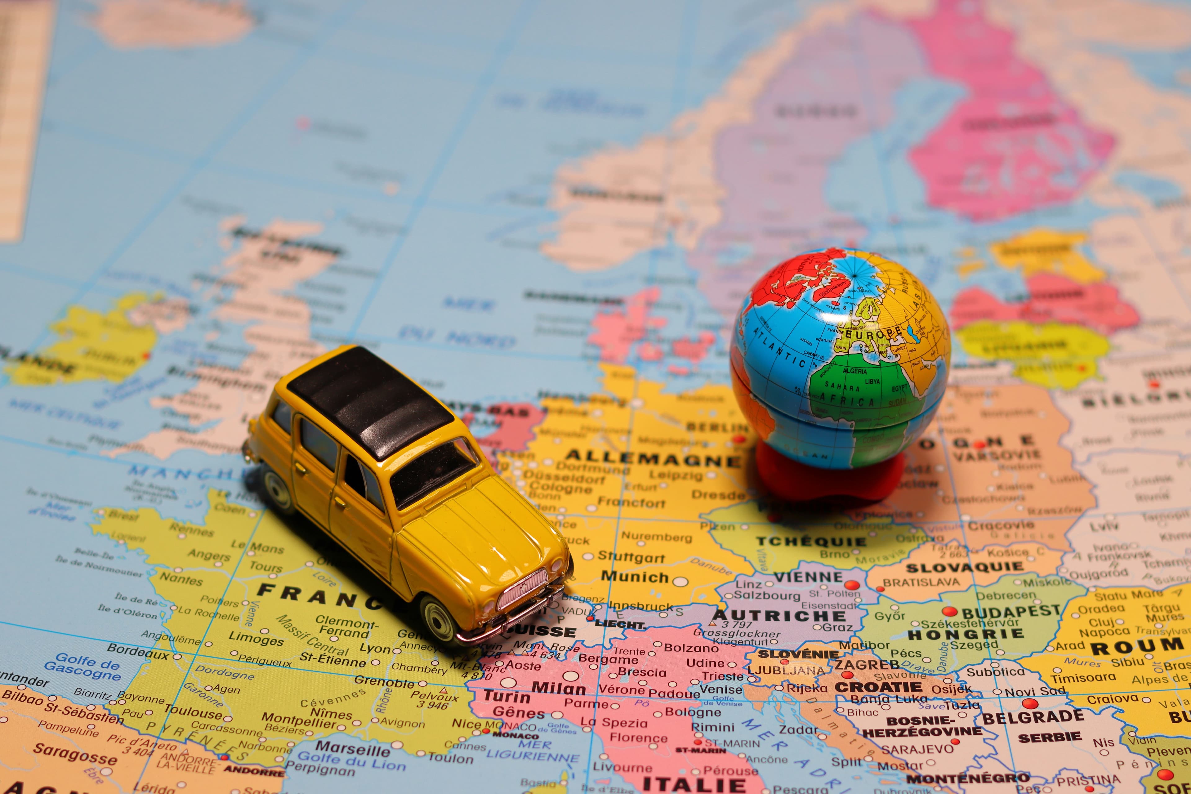 Toy car and globe on a map